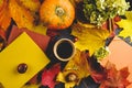 Coffee mug, autumn maple leaves, pumpkin and colourful books .
