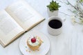 Coffee mug and book with plants on table