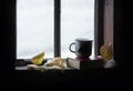 Coffee mug and book on windowsill