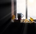 Coffee mug and book on windowsill