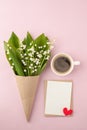 Coffee mug with bouquet of flowers lily of the valley and blank with red heart oj pink pastel background, beautiful breakfast, vin Royalty Free Stock Photo