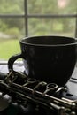 Mug and clarinet in a window on table