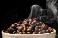 Coffee mug full of coffee beans with smoke