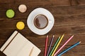 Coffee mug, macarons, colored pencils and a notepad on a wooden background Royalty Free Stock Photo