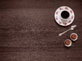 Coffee mug on a saucer, a teaspoon, two candies on a wooden back Royalty Free Stock Photo