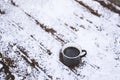 Coffee mug on snowy wooden table, outdoors