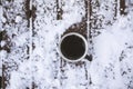 Coffee mug on snowy wooden table, outdoors