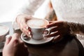 Coffee mugs of cappuccino in the hands of a loving couple Royalty Free Stock Photo