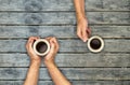 Coffee mugs hands holding on wood table Royalty Free Stock Photo