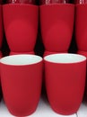 Coffee mugs (red color) kept in a row in crockery store. Tea mugs (cups) set in a shop closeup image photo.