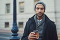 Coffee is my fuel. a fashionable young man in an urban setting. Royalty Free Stock Photo