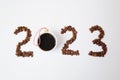 Coffee New Year 2023 concept. Number made of coffee beans. A cup of black espresso coffee as a Christmas ball. On white Royalty Free Stock Photo