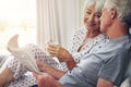 Coffee, newspaper and a senior couple in the bedroom, enjoying retirement in their home in the morning. Tea, reading or Royalty Free Stock Photo