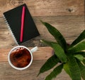 Coffee, notebook, pen and plamt