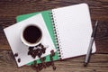 Coffee, opened notebook and pen