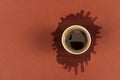 Coffee in paper cup on brown background with stain. Spilled espresso on table. Glass with americano on coffee stain. Top Royalty Free Stock Photo