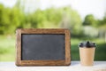 coffee paper cup with chalk board, on wood table, summer day background Royalty Free Stock Photo