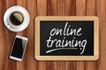 Coffee, phone and chalkboard with online training words Royalty Free Stock Photo