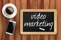 Coffee, phone and chalkboard with video marketing words Royalty Free Stock Photo