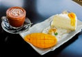 Coffee with a piece of mango cheese cake on table wooden Royalty Free Stock Photo
