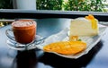 Coffee with a piece of mango cheese cake on table wooden Royalty Free Stock Photo