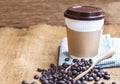 Coffee plastic cup with cardboard sleeve and a pile of coffee be Royalty Free Stock Photo