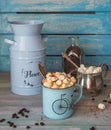 Coffee with a plentiful marshmallow slide and chocolate. Floral blue flower pots and sugar bowl with marshmallows