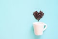 Coffee poster advertisement. White cup with coffee beans arranged in heart shape on pastel colour Royalty Free Stock Photo