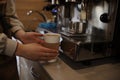 The barista prepares coffee on a professional coffee machine. Coffee in a paper glass in the background of a coffee machine Royalty Free Stock Photo