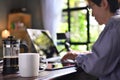 A coffee press and a cup on a work desk with a person working from home