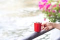 Coffee red cup on a fence of canal nature background