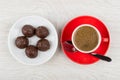 Coffee in red cup on saucer, spoon and chocolate candy Royalty Free Stock Photo