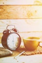 Coffee with retro clock on wood table background. Royalty Free Stock Photo