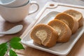 Coffee roll cake with cream on plate and coffee cup Royalty Free Stock Photo