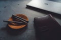 Coffee saucer, luxury pens, laptop and notebook on concrete table