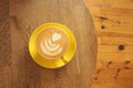 Coffee served on a yellow cup on a wooden table Royalty Free Stock Photo
