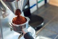 Coffee Shop. Barista grinding coffee using eletric grinder close-up