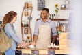 Coffee shop, customer and waiter talking about service, hospitality or smile of a man. Happy woman buying tea at a Royalty Free Stock Photo