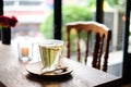 In coffee shop, the hot lavender tea in glass serve with wooden spoon & saucer on the table with chair for relax and slow life Royalty Free Stock Photo