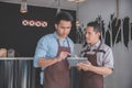 Coffee shop owner discussing with his employee using tablet