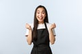 Coffee shop, small business and startup concept. Cheerful asian girl winning, best employee month, fist pump and Royalty Free Stock Photo