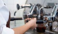 Coffee shop staff dressed in brown apron making fresh espresso coffee Royalty Free Stock Photo