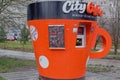 Coffee shop stall in shape of orange mug with inscription at top