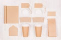Coffee shop template for branding identity - two brown paper cups with blank notebook, packet, label, card, cap, envelope on wood. Royalty Free Stock Photo