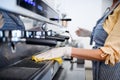 Coffee shop woman owner working with gloves , disinfecting machine.