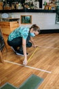 Coffee shop worker measuring floor marks