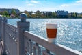 Coffee single cup on the fence The lake and the city in bokeh are on the background.