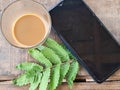 Coffee with smartphone and green fern leaf on rustic wooden table Royalty Free Stock Photo