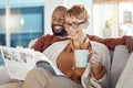 Coffee, sofa and senior couple with newspaper reading story or article while drinking espresso. Black couple, tea and Royalty Free Stock Photo