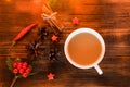 Coffee, spices and pine cones on a wooden background. Christmas concept. A cup of hot coffee with milk, cinnamon and chili on a wo Royalty Free Stock Photo